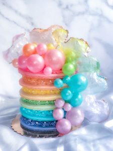 Pastel rainbow macaron cake with gelatin bubbles and rice paper heart sails